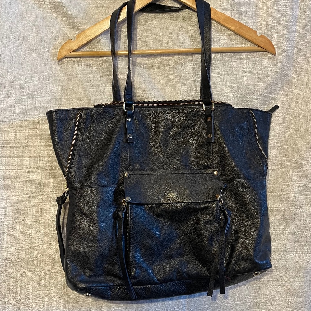 Black leather Kooba Everette Tote featuring expandable side zippers and a front